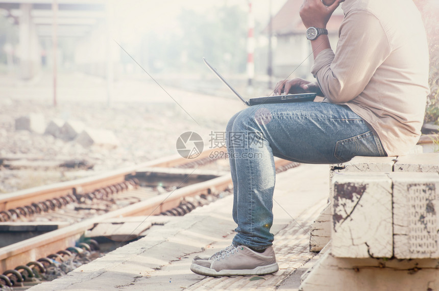 人们在火车站用笔记本电脑坐在一个火车站的商人通过定制古代口音进行摄影设计男旅行图片