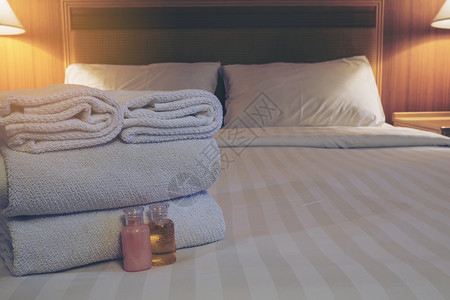 干净的住宿白色床铺有洗发水和肥皂瓶的旅馆毛巾枕头图片
