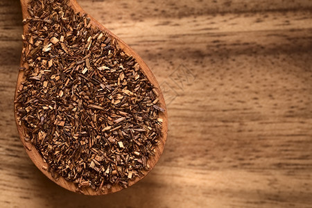 木勺上的Rooibos草药茶用自然光在木头上拍下照片选择焦点关注顶叶晒干红灌木草本植物图片
