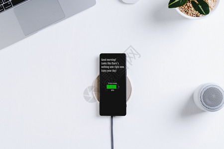 活力安卓电话无线充器白桌背景的智能手机充电背景图片