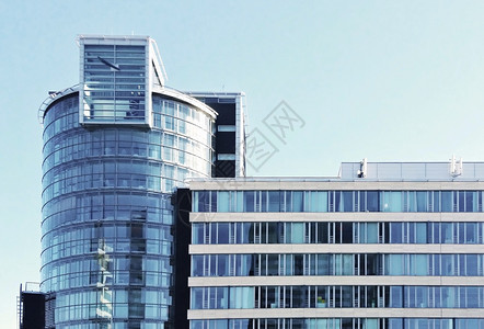 抽象的办公室现代玻璃建筑的正面景象以蓝天为对面反射图片