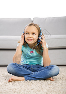 坐在地上戴着耳机的可爱小女孩图片