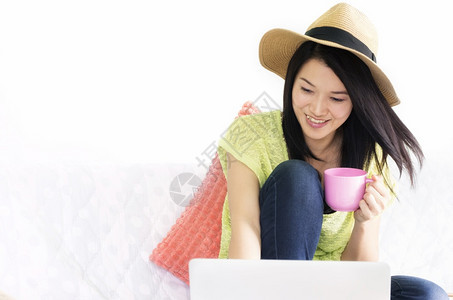 吸引人的商业粉色快乐年轻女使用笔记本电脑并用笔记本电脑在室内妇女面前端着粉红杯咖啡图片