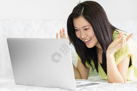 在室内坐着商业使用笔记本电脑的年轻美丽亚洲女室内使用笔记本电脑图片