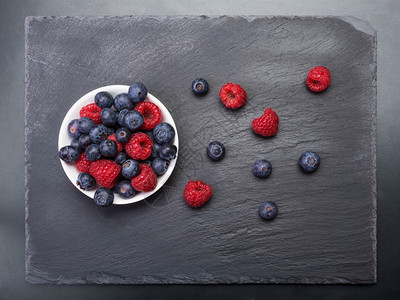 自然可口吃散布在黑背景图视上的新鲜草莓和浆果图片