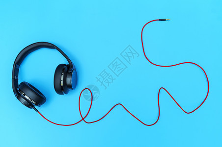 个人的用在装饰和设计中使用的蓝色背景黑耳机和红电缆子的黑色图片