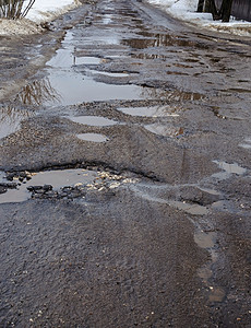 有大坑洞和泥水的公路春季肮脏的坑洼时间图片