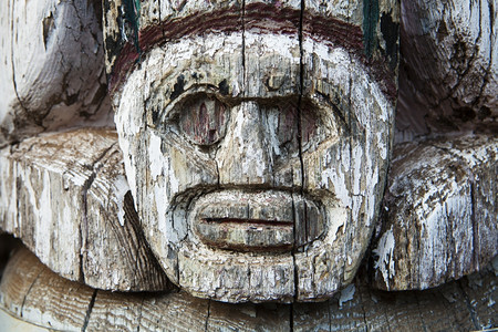 艺术在一个童子军营地的古老图腾柱上可以看到一张面孔的小细节木头碎裂油漆正在剥皮男生艺术的图片