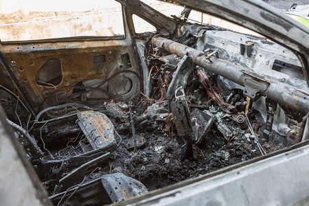 破坏生锈的路街上被烧毁汽车特写街上被烧毁的汽车特写图片