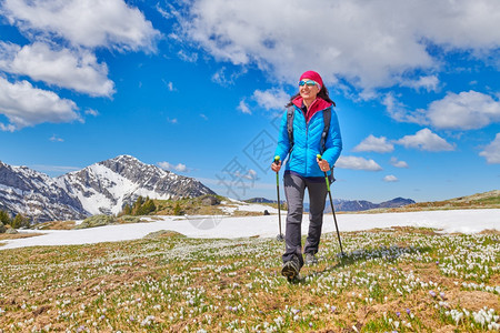 女孩在草地大展期间带着静雪和花椰子跋涉背包闲暇图片