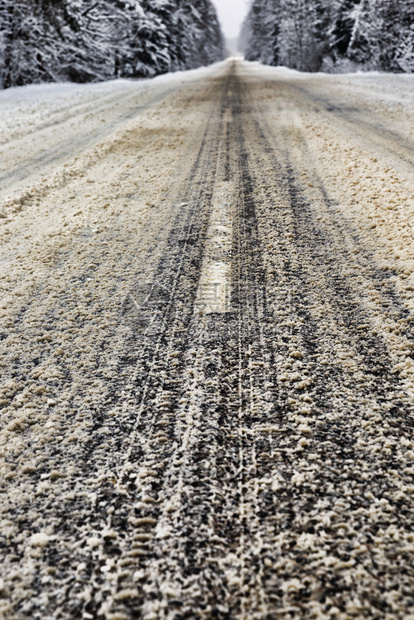 或者冬季的沥青路分为几个小道在暖化或解冻期间公路上的雪开始融化冬季道路关闭建筑学外部的图片