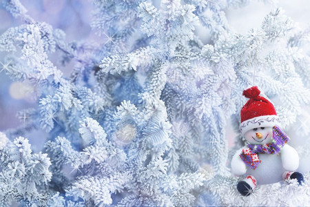 红圣诞雪人挂在冬森林的树枝上玩具分支帽子图片