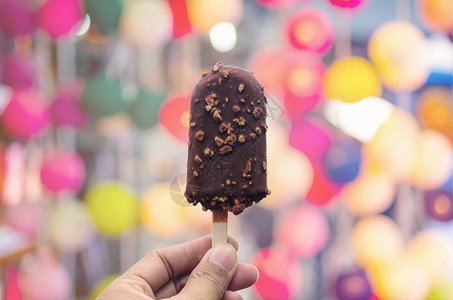 目的颜色手握冰淇淋上面涂有巧克力的冰淇淋在天然模糊背景上手握冰淇淋食物图片