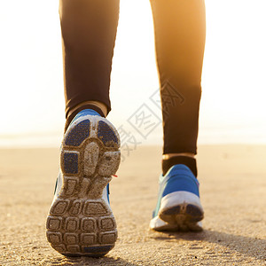 走运动员美丽健康的女人在沙滩上奔跑慢者图片