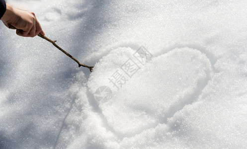 寒冷的霜一只手用棍子在雪中画出爱心冬天图片