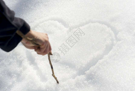 自然地面冷若冰霜一只手用棍子在雪中画出爱心图片