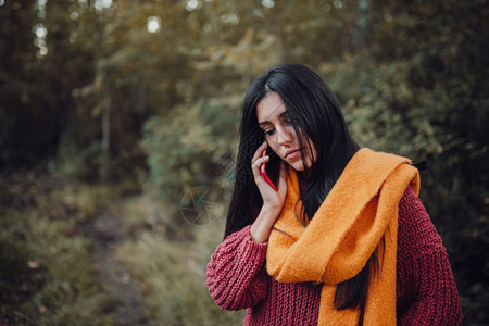 秋季森林里使用手机的女生图片