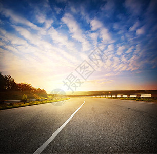 晚上路边自由傍的风景与一条通向日落天空地平线的道路图片