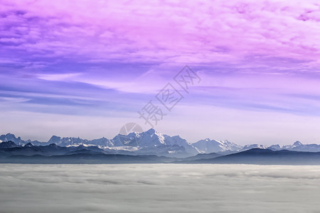 白色的阿尔卑斯山脉MontBlanc在日落时云层上分布法国之蓝色的图片