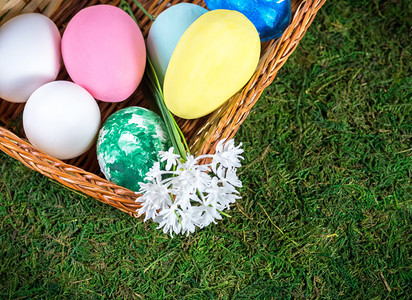 有色季节在绿草坪上配有彩色东方鸡蛋的篮子花图片