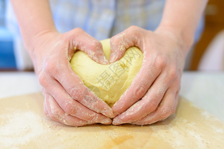 女士食物烹饪人手亲打结面袋近身手指形成心脏状制造图片