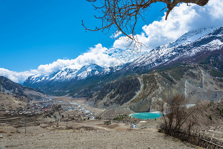 喜马拉雅山上美丽的雪峰和云彩在尼泊尔马南村附近的一个小绿化湖蓝色的徒步旅行天空图片