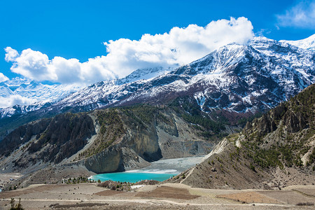 翠风景喜马拉雅山上美丽的雪峰和云彩在尼泊尔马南村附近的一个小绿化湖村庄图片