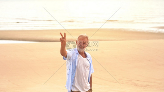 在沙滩上快乐的老人假期退休图片