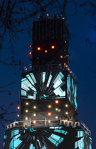 多媒体塔夜间有许多发光的LED屏幕聚光灯和彩色霓虹效果具有音乐和灯光效果的娱乐活动技术夜晚明亮的图片
