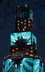 居住氖多媒体塔夜间有许多发光的LED屏幕聚光灯和彩色霓虹效果具有音乐和灯光效果的娱乐活动俱部图片