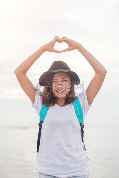 年轻女做心脏形状的女人夏日时光水平室外海边滩背景享受水平的爱图片