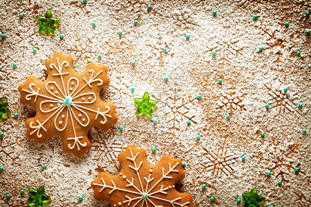饼干蓝色的甜雪花上姜饼由木制餐桌上的冰糖做成圣诞装饰品图片