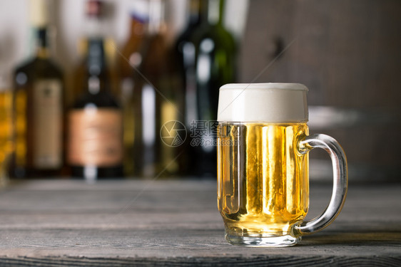 在酒吧架子背景的轻啤酒杯黄色的品脱液体图片