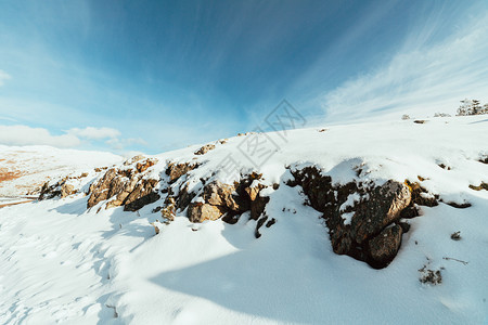寒冷日出时山上满是蓝天空的雪覆盖了山上岩石风景优美季节图片