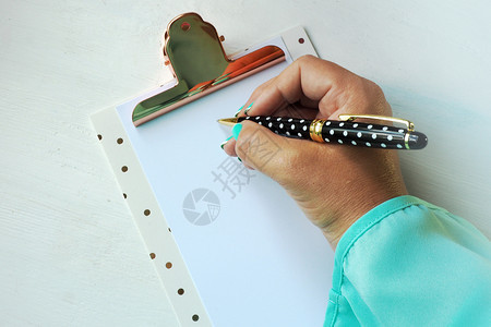 工作一种波尔卡女在剪贴板纸上用圆点笔写字一张干净的纸页写字图片