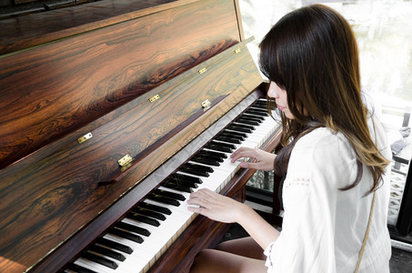 旋律弹钢琴的亚洲女美丽人图片