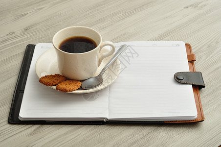 一杯咖啡饼干和笔记本美味的健康小吃图片