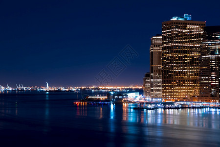 美国纽约市曼哈顿上海湾的摩天大厦和距离曼哈顿自由女神像的夜景曼哈顿和自由女神像全景建筑学晚上图片
