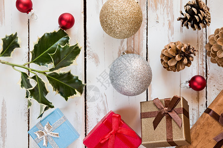 扫帚关闭圣诞礼物和装饰放在从圣诞礼物和装饰上方的生锈木制餐桌前看的铁木餐桌上以及一个生锈木制餐桌上的装饰木制绿色图片