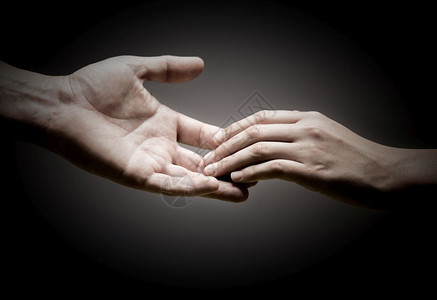 团结一致的友谊黑背景团结或同情的理念两只手相互触碰彼此不相识图片