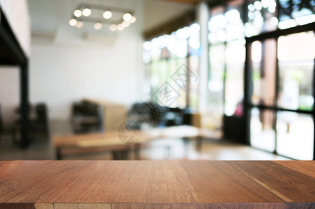 现代的咖啡店餐厅背景模糊的咖啡厅面前空木板桌图像可以是摆放产品木制的商业图片