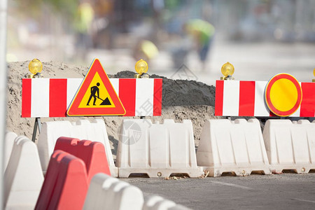道路有危险标志和道路修复的防堵而道路则被阻断在城市街道上修筑路工人象征围栏图片