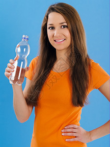 一位美丽的年轻黑发女人在蓝底饮水瓶装的照片她写道头发一种年轻的图片