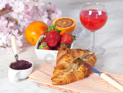 草莓果酱维生素杯子早晨美味餐果汁和羊角面包背景