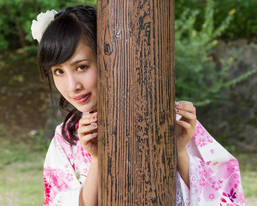 传统建筑学和服的亚洲女人玩耍从木柱后面偷窥出来女士图片