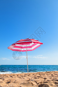 清空海滩有浪和条纹粉红色阳伞阴凉处离开科斯塔图片