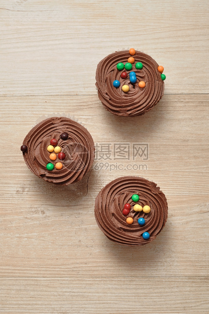 庆典巧克力杯饼霜冻和彩色糖果装饰的巧克力蛋糕美味的对待图片