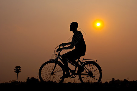 骑术日落男孩为健康而骑自行车的休养假年轻图片