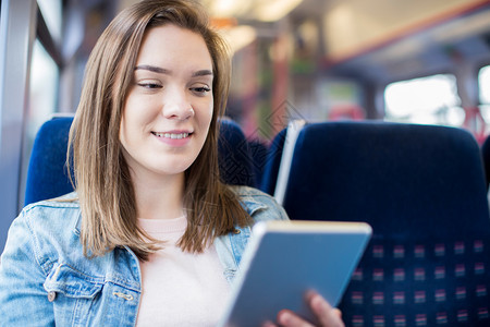 乘客工作女青年在火车旅程中使用数字板块微笑图片