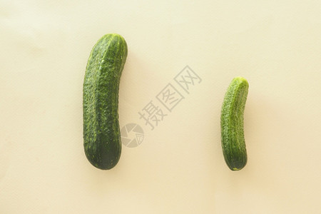 治疗功能障碍两只绿黄瓜以不同尺寸雄的蜜蜂背景概念绿色图片